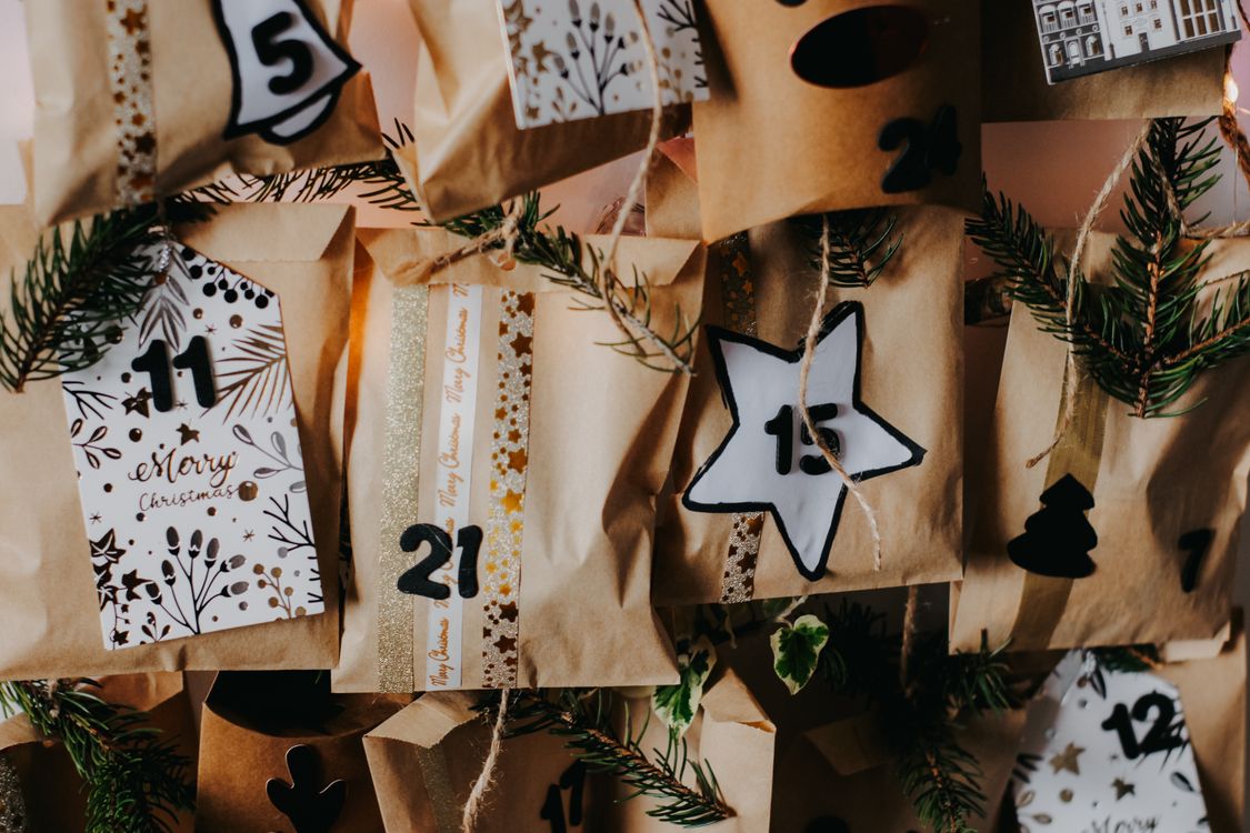 Close-up van een zelfgemaakte adventskalender met genummerde tasjes en dennentakjes