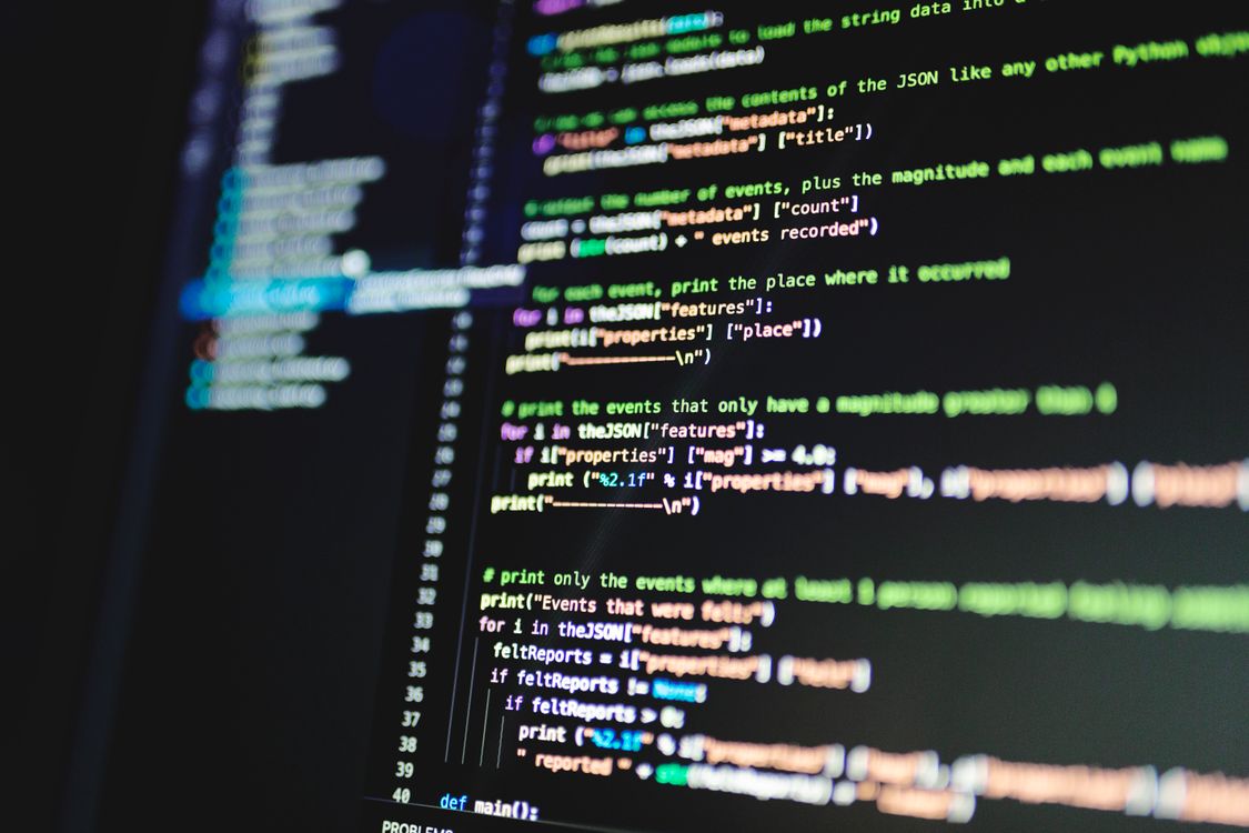 Close-up van kleurrijke programmeercode op een beeldscherm, symbool voor de laag onder AI-tekstgeneratie