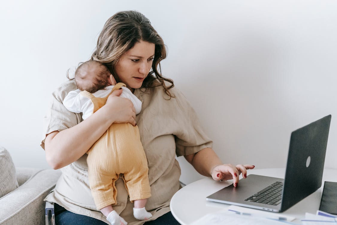 Een werkende moeder met haar baby — zorg en vermoeidheid gaan vaak hand in hand