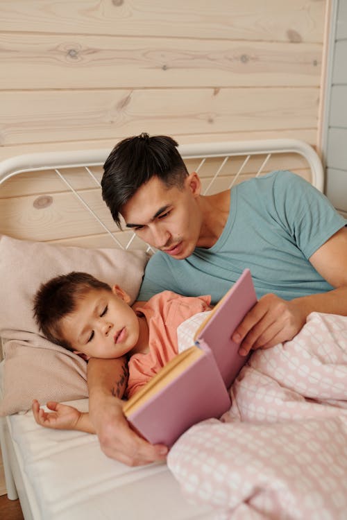 Vader leest gepersonaliseerd boek voor aan zijn kind in bed