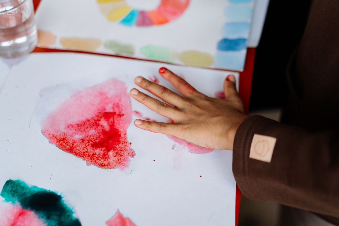 Een kind schildert met waterverf, symbool voor de creativiteit achter personalisatie