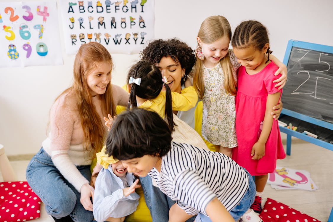 Kinderen in klaslokaal met alfabet-poster aan de muur