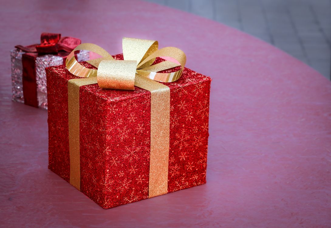 Een rood cadeau met gouden lint, klaar voor pakjesavond