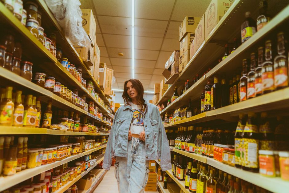Winkelwagen in een supermarktgangpad met volle schappen
