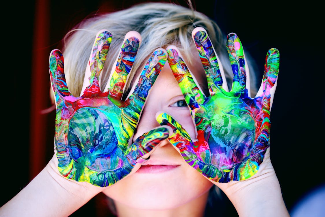 Kind met handen vol verf als symbool voor eigen creativiteit en originele personages