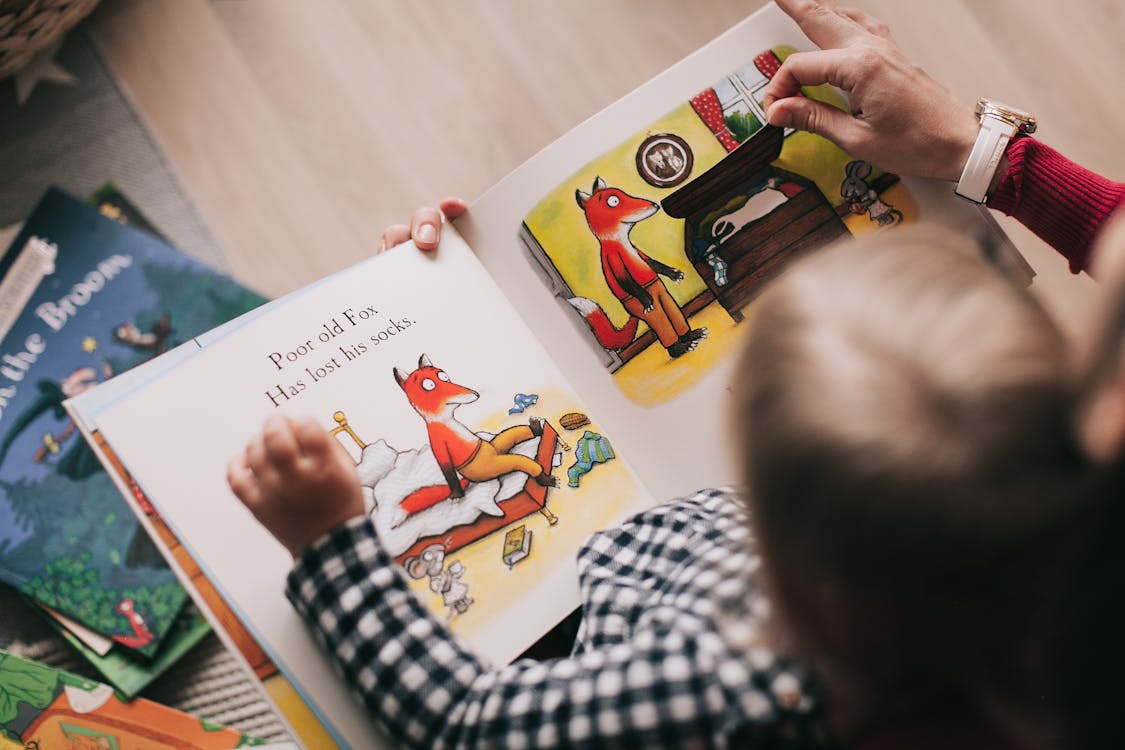 Kind bekijkt een prentenboek met een origineel getekend vosje
