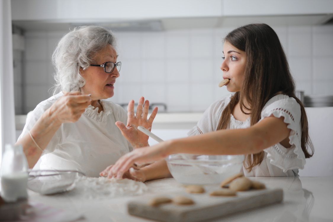 Oma en kleindochter in gesprek in de keuken