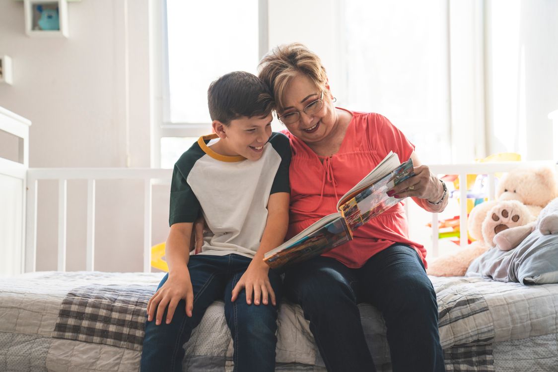 Een oma leest samen met haar kleinzoon een boek, een moment van taal, herhaling en betrokkenheid