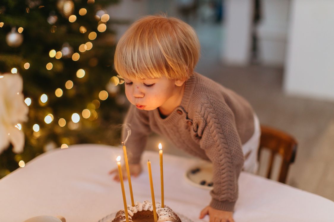 Kind blaast de kaarsjes uit op een verjaardagstaart