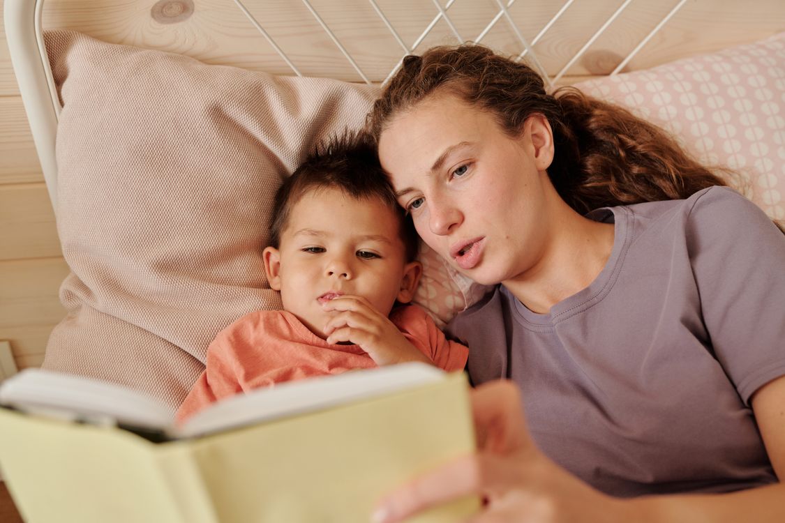 Ouder leest een kind een vertrouwd verhaaltje voor in een gezellige slaapkamer