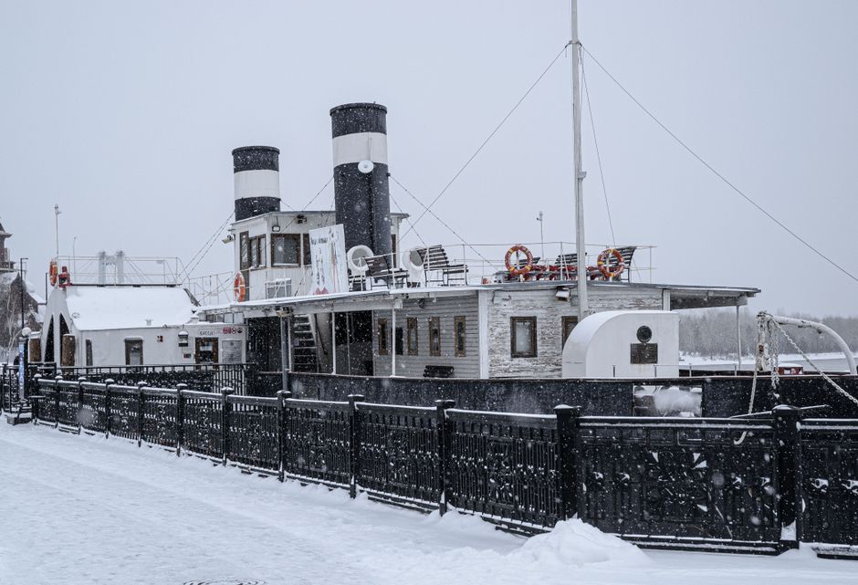 Een oude stoomboot in een besneeuwde haven