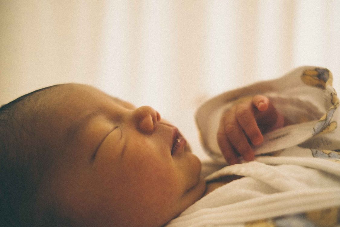 Pasgeboren baby slaapt vredig in een wiegje