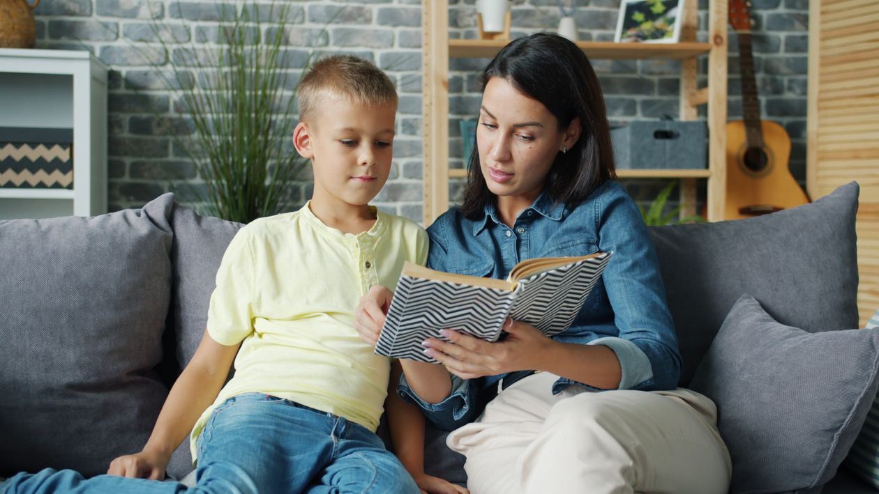 Moeder en kind lezen samen een boek op de bank